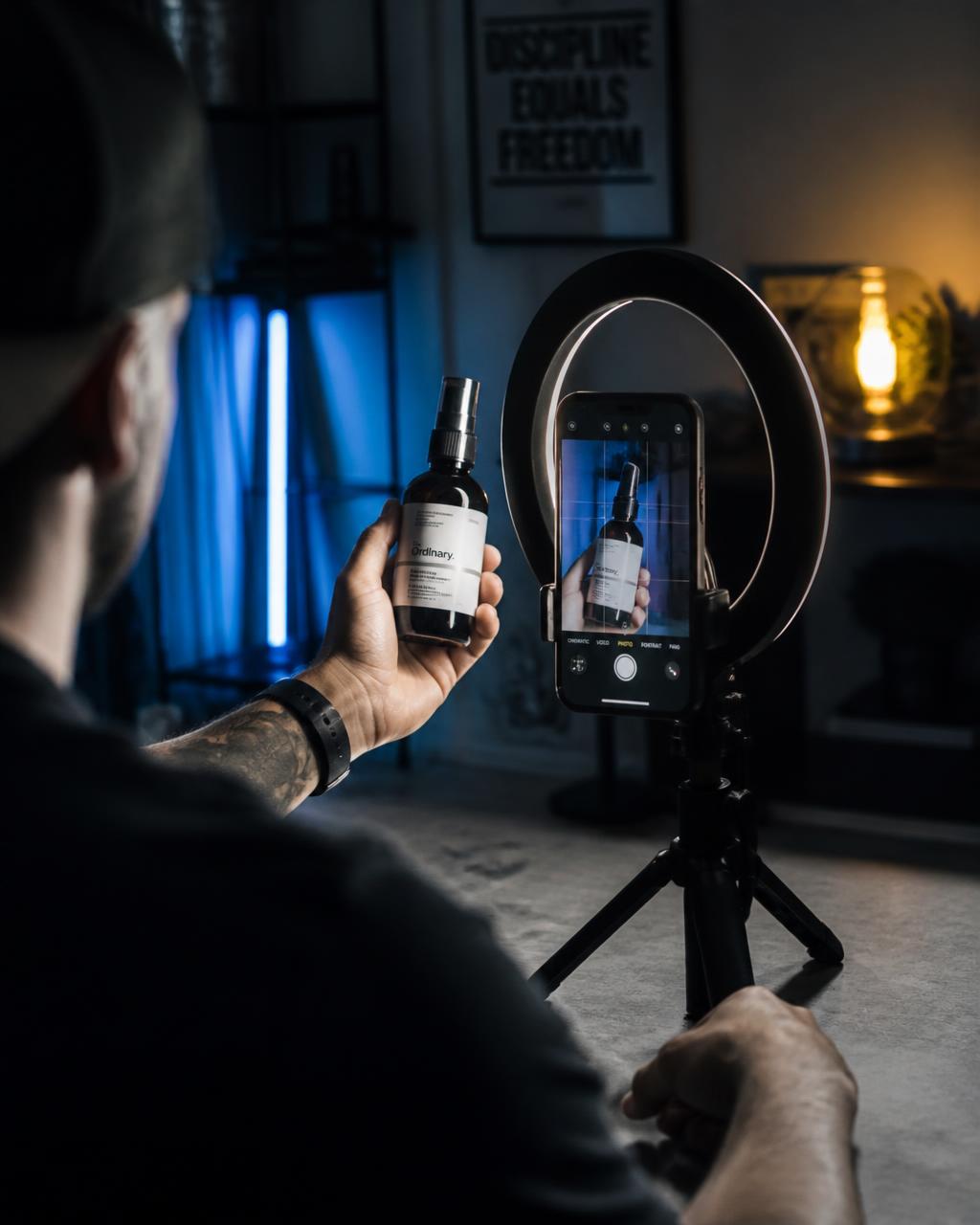 A creator filming a product with a ring light in a dark room.